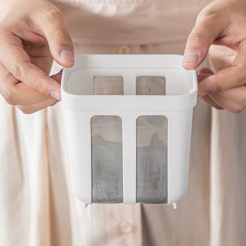 ידיים מחזיקות את מסננת היוגורט מקרוב, מדגימות את מבנה הרשתות הפנימיות לסינון עדין.

